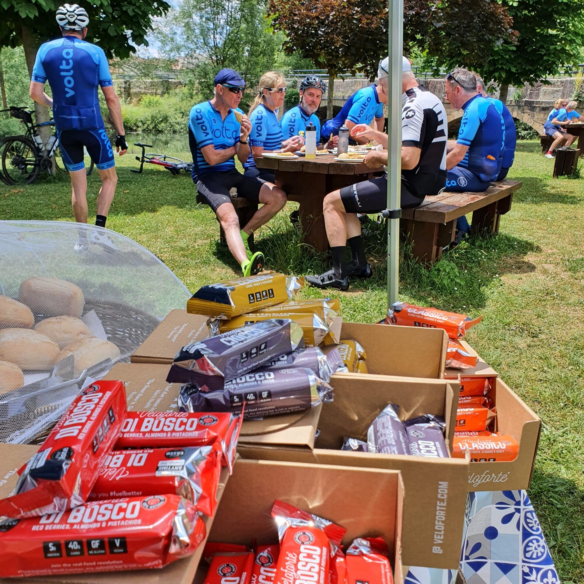 Group of cyclists stopped at a riverside feed station during the Trans Iberian 600k. Riverside Feed Stop – Trans Iberian 600k